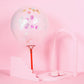 Iridescent round foil metallic confetti dots on a pink balloon decor.