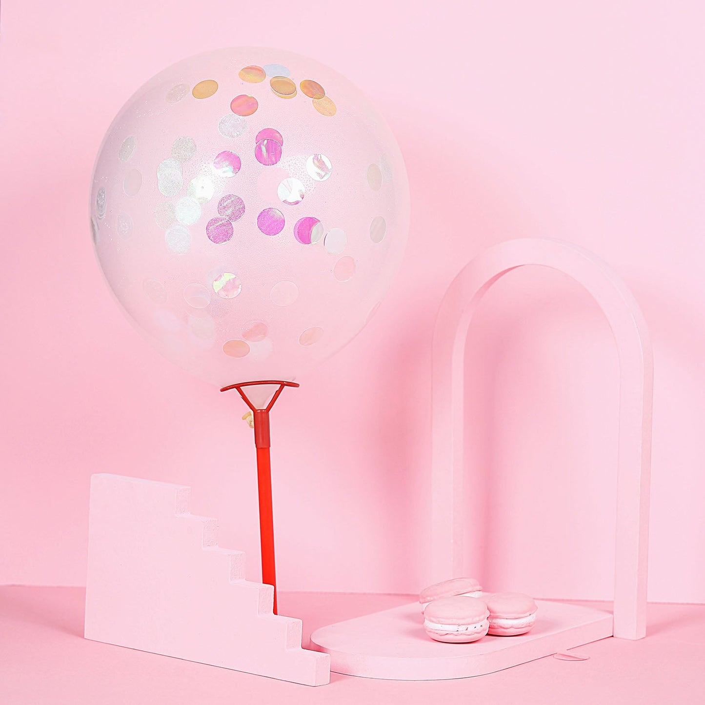 Iridescent round foil metallic confetti dots on a pink balloon decor.