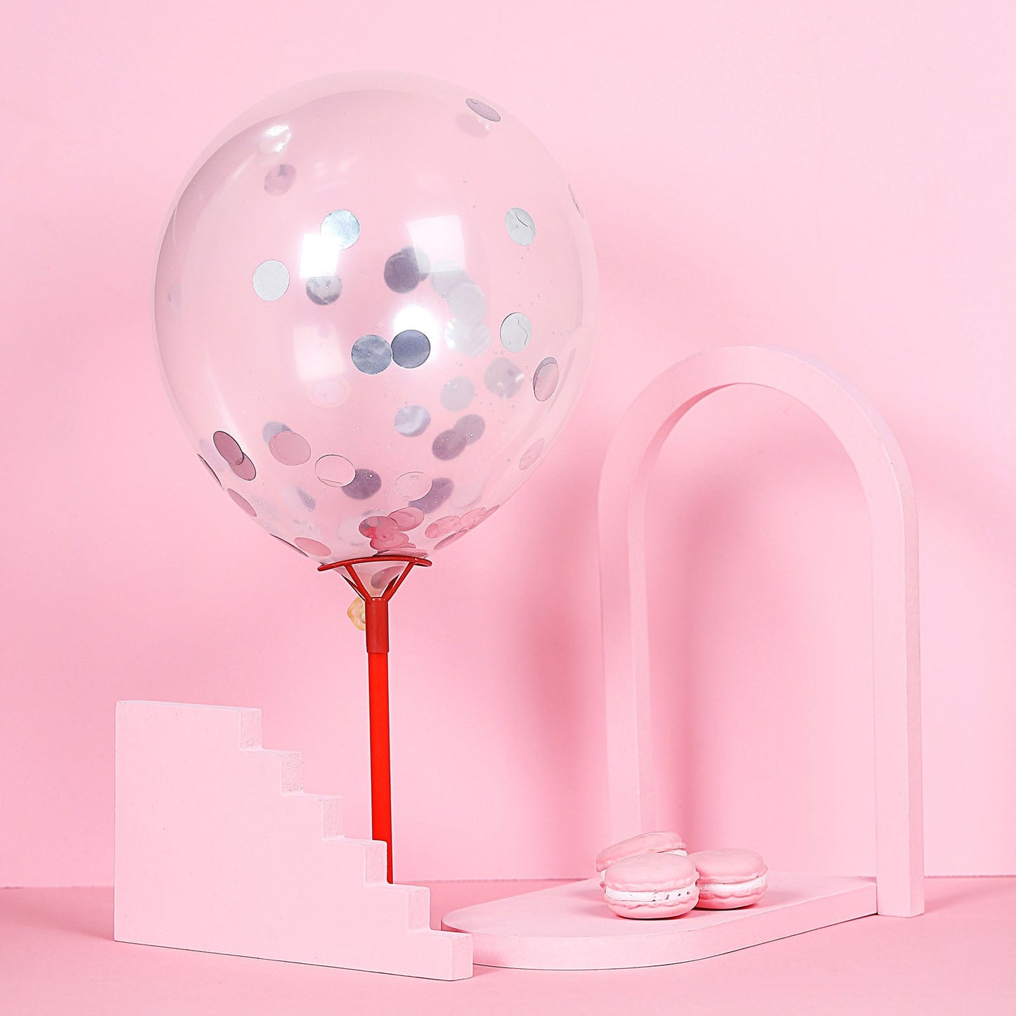 Silver round foil metallic table confetti dots on a pink balloon decoration.