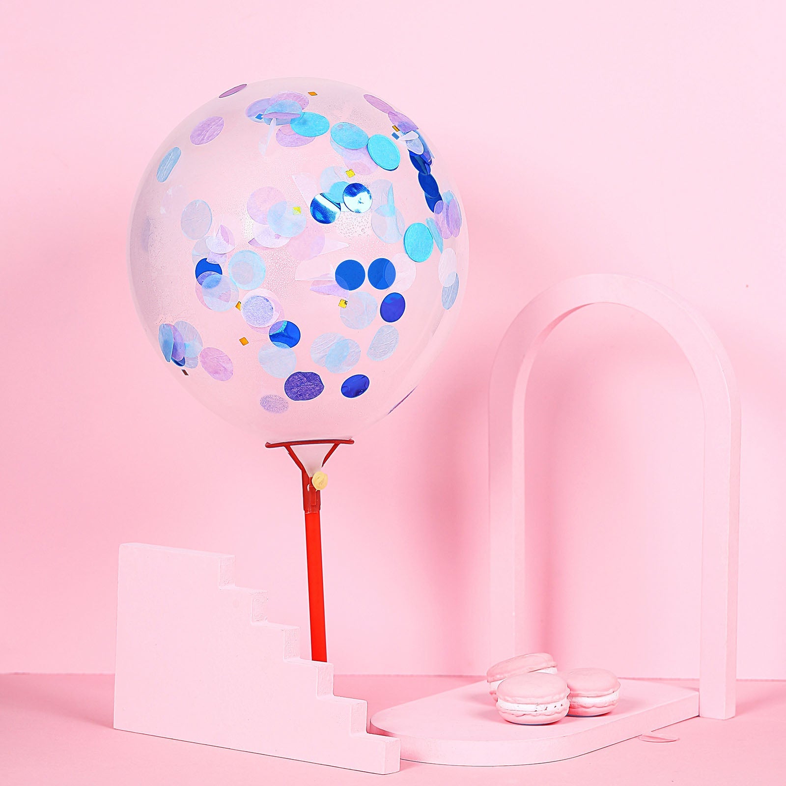 Purple and blue confetti balloon on a pink backdrop.