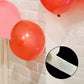 Clear removable balloon arch glue dots on red balloons.