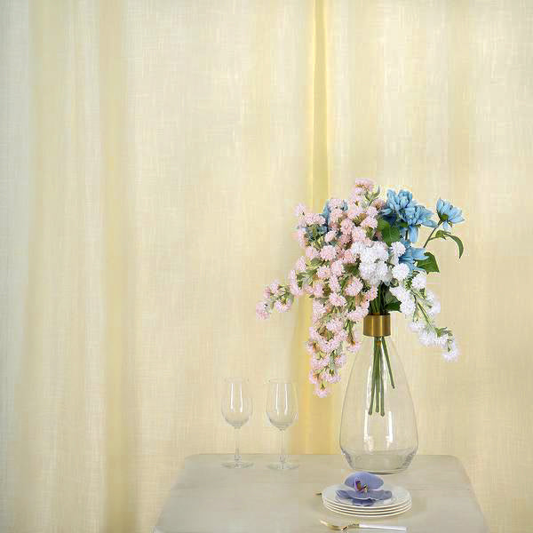 Ivory faux linen curtains with chrome grommets and floral arrangement.