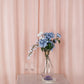 Blush faux linen curtains with chrome grommets and floral arrangement.
