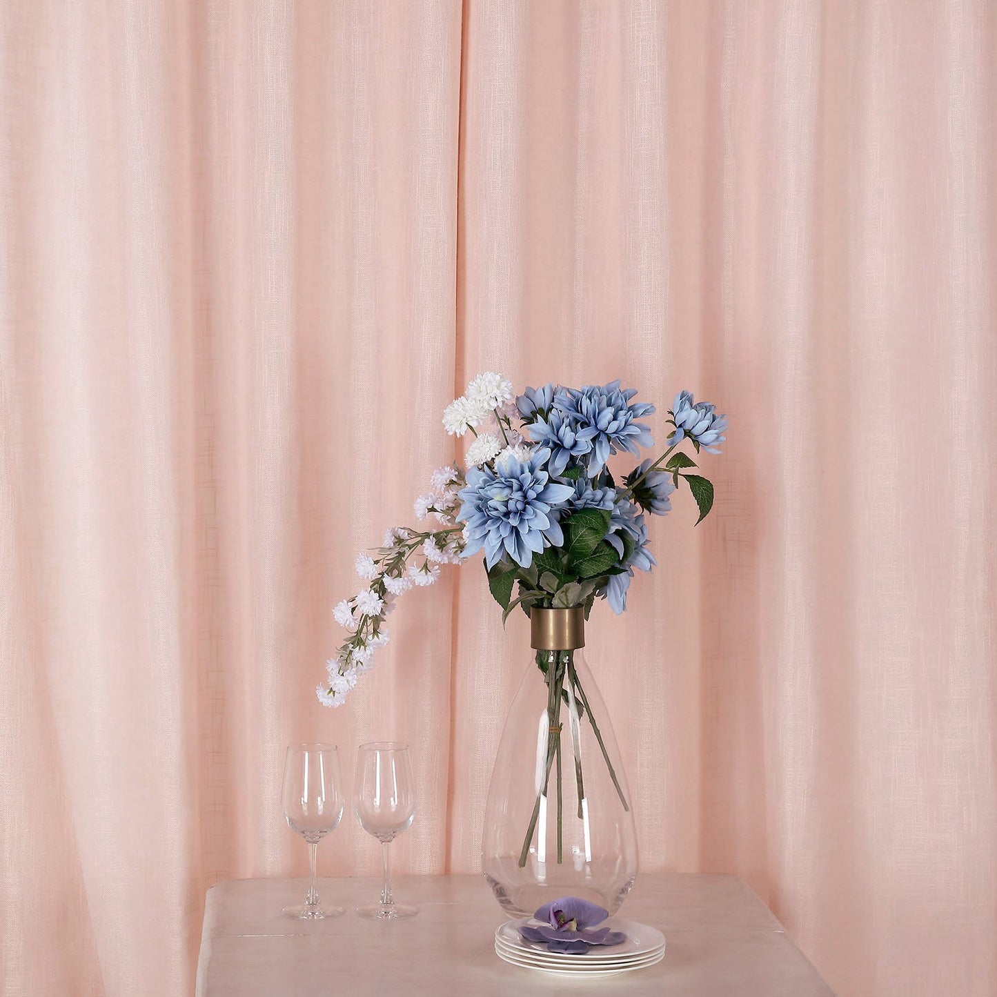 Blush faux linen curtains with chrome grommets and floral arrangement.