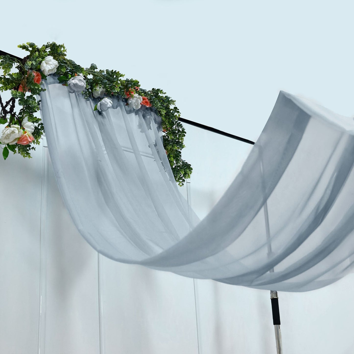 Dusty blue chiffon curtain panel draped with floral accents.
