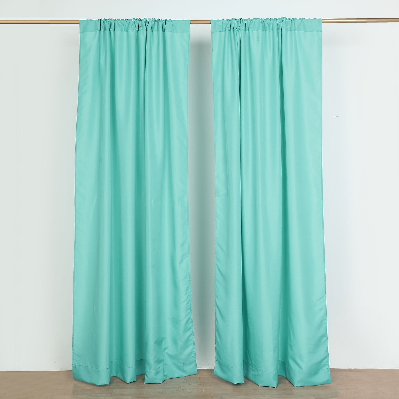 Turquoise polyester backdrop drape curtains with rod pockets.