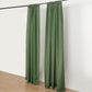 Olive green polyester backdrop drape curtains on a rod.