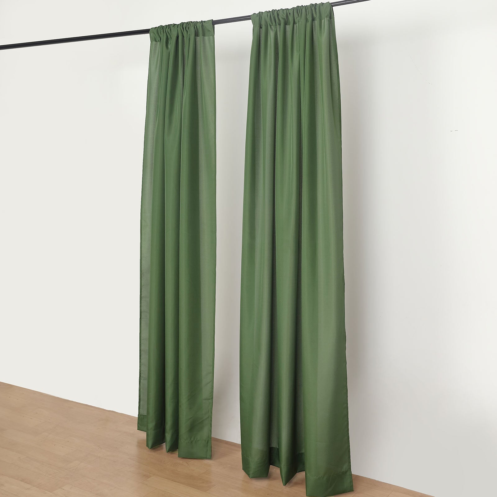 Olive green polyester backdrop drape curtains on a rod.