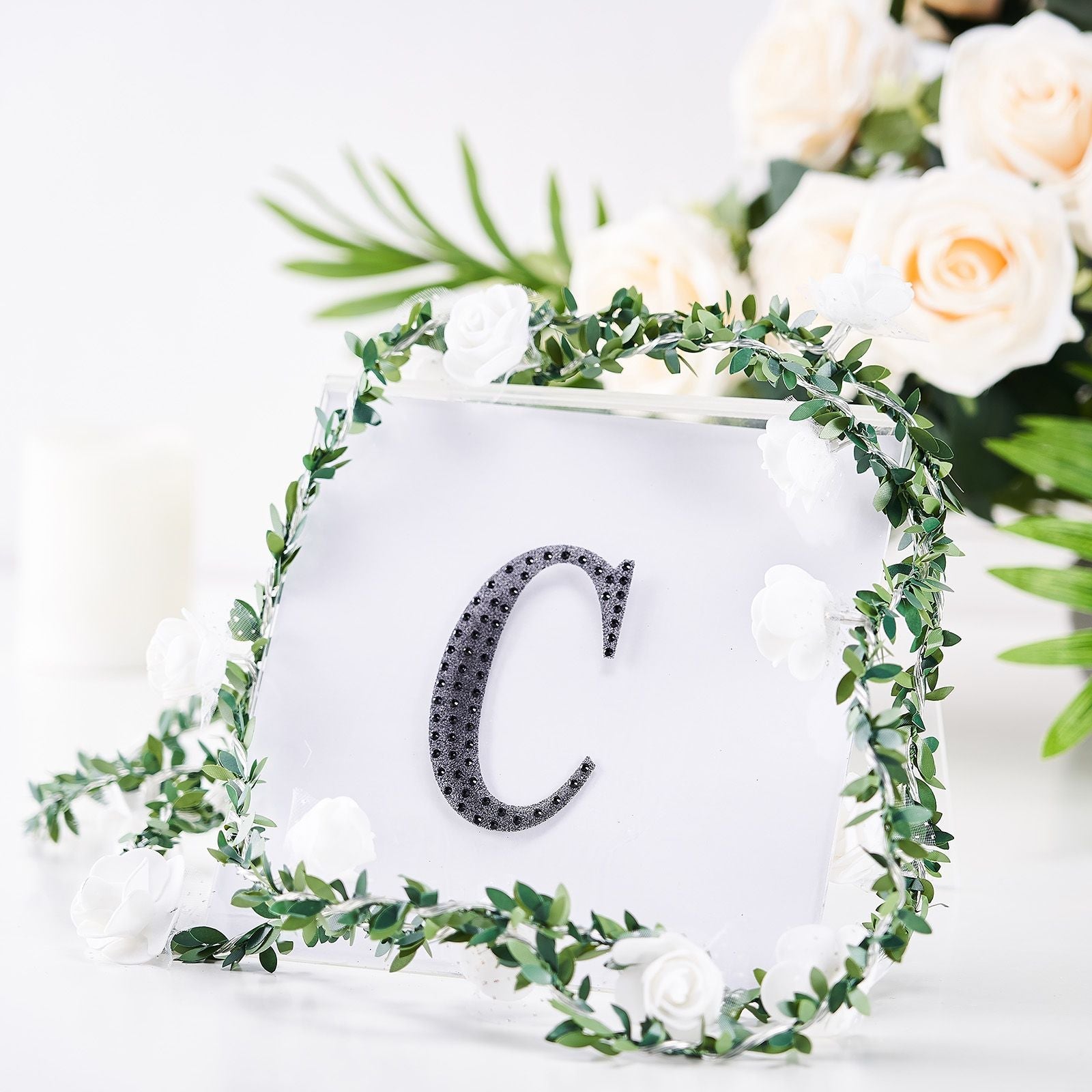 Black decorative rhinestone letter "C" with floral accents.
