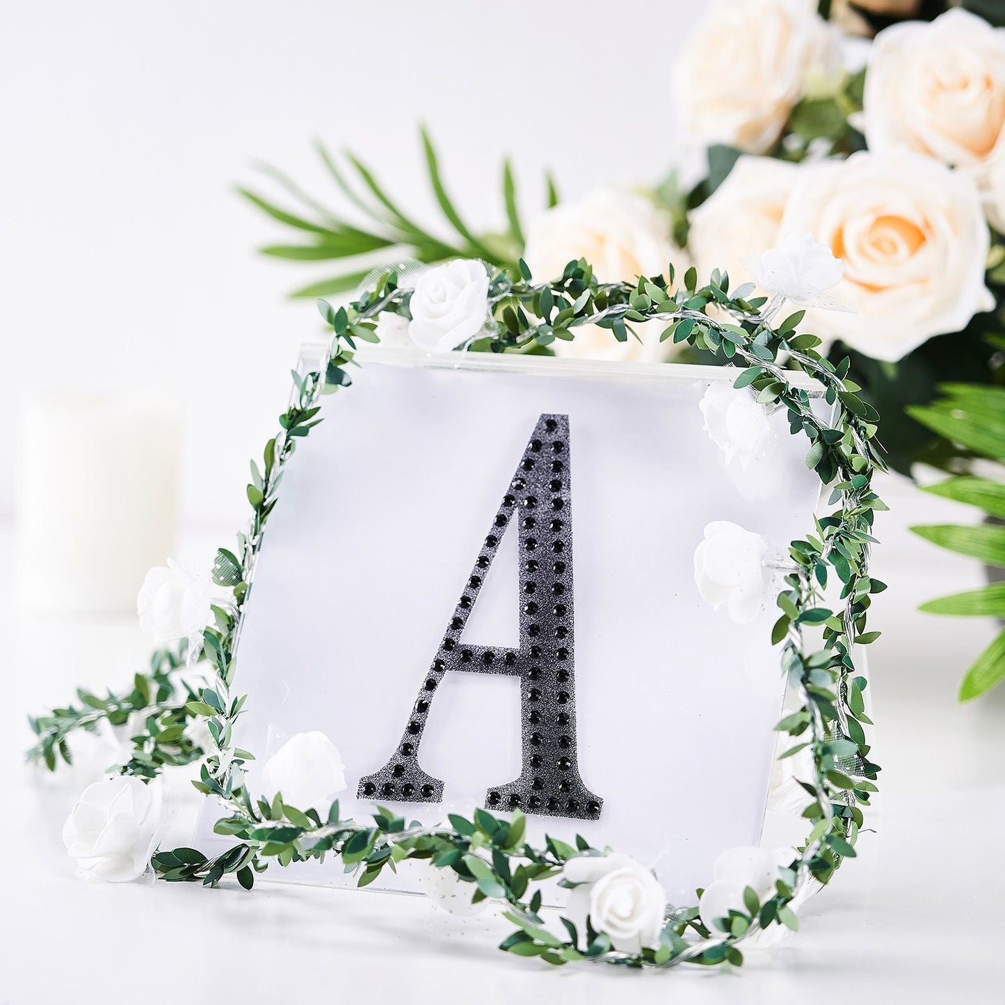 Black decorative rhinestone letter "A" with floral accents.