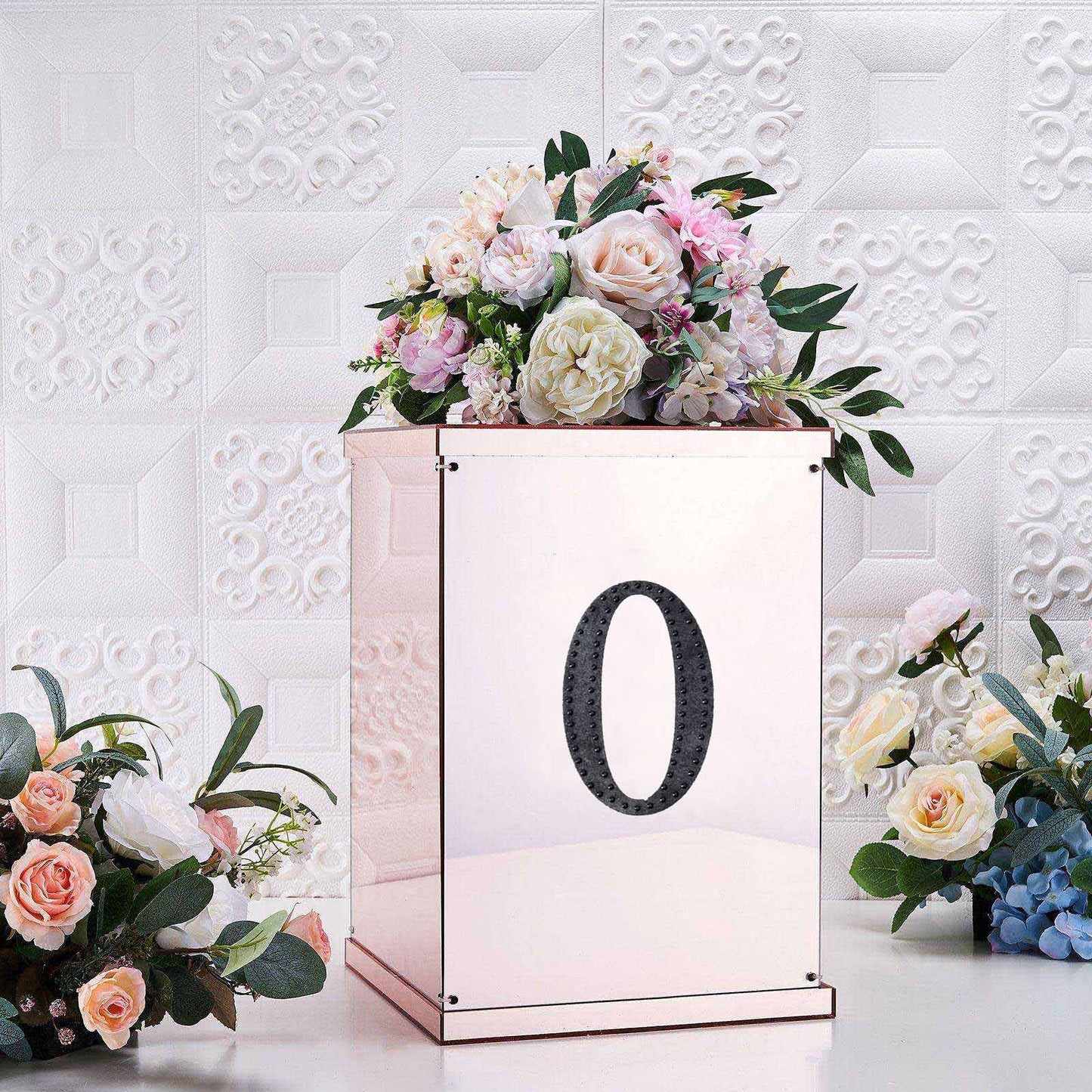 Black decorative rhinestone letter "O" on a floral arrangement.