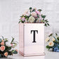 Black decorative rhinestone letter "T" sticker on a floral arrangement.