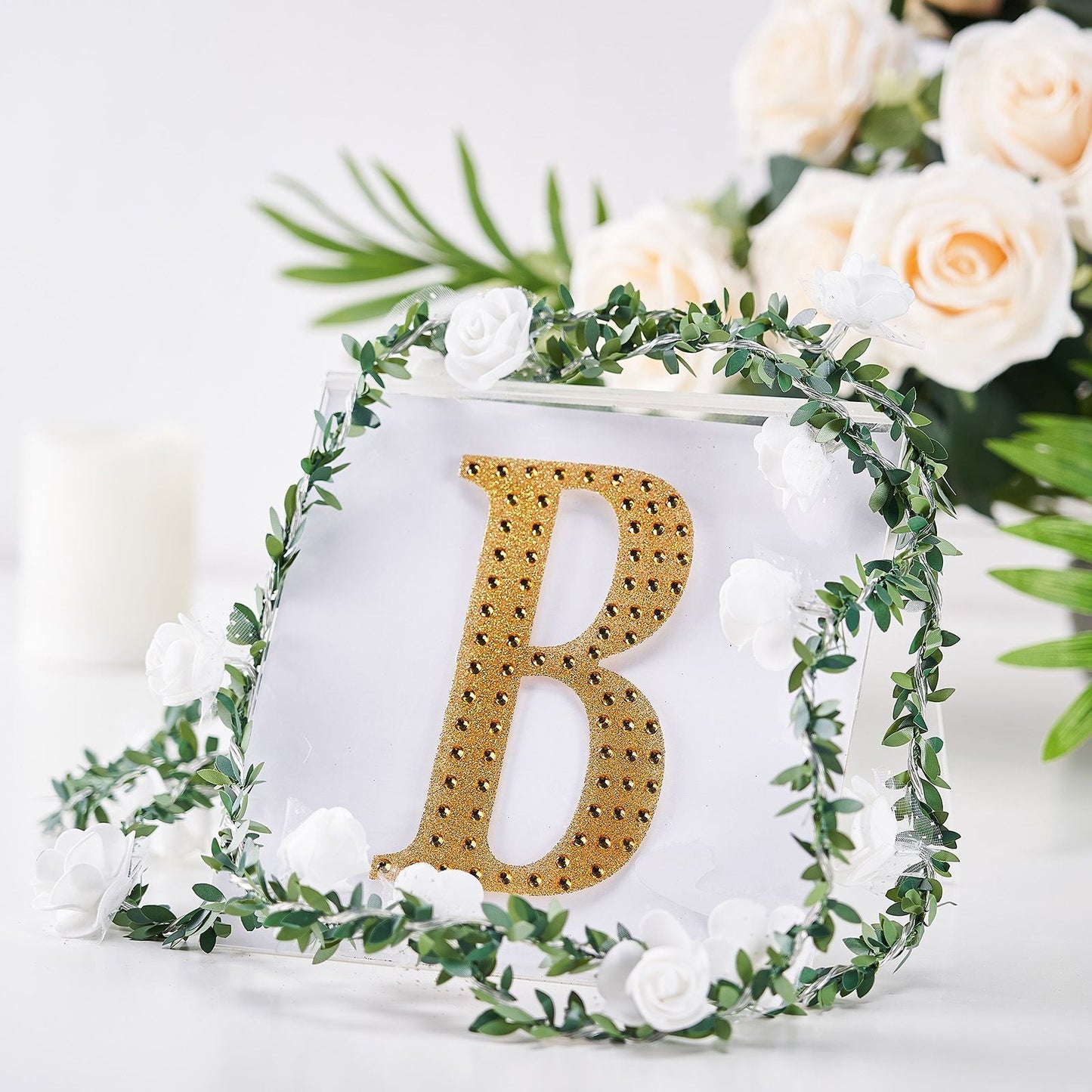 Gold decorative rhinestone letter "B" with floral accents.