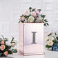 Silver decorative rhinestone letter "I" on a mirrored box with flowers.