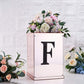 Black decorative rhinestone letter "F" on a floral arrangement.