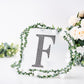 Black decorative rhinestone letter "F" with floral accents.
