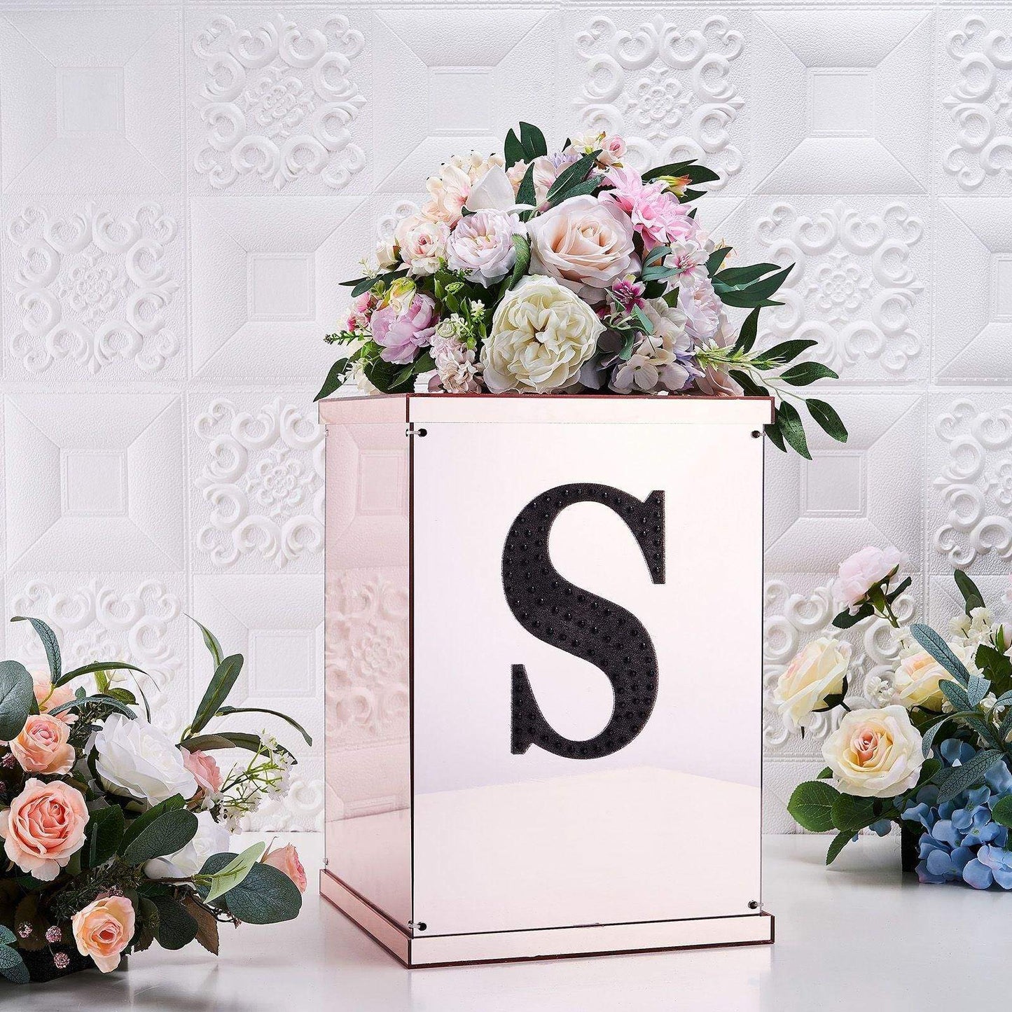 Black decorative rhinestone letter "S" on a floral arrangement box.