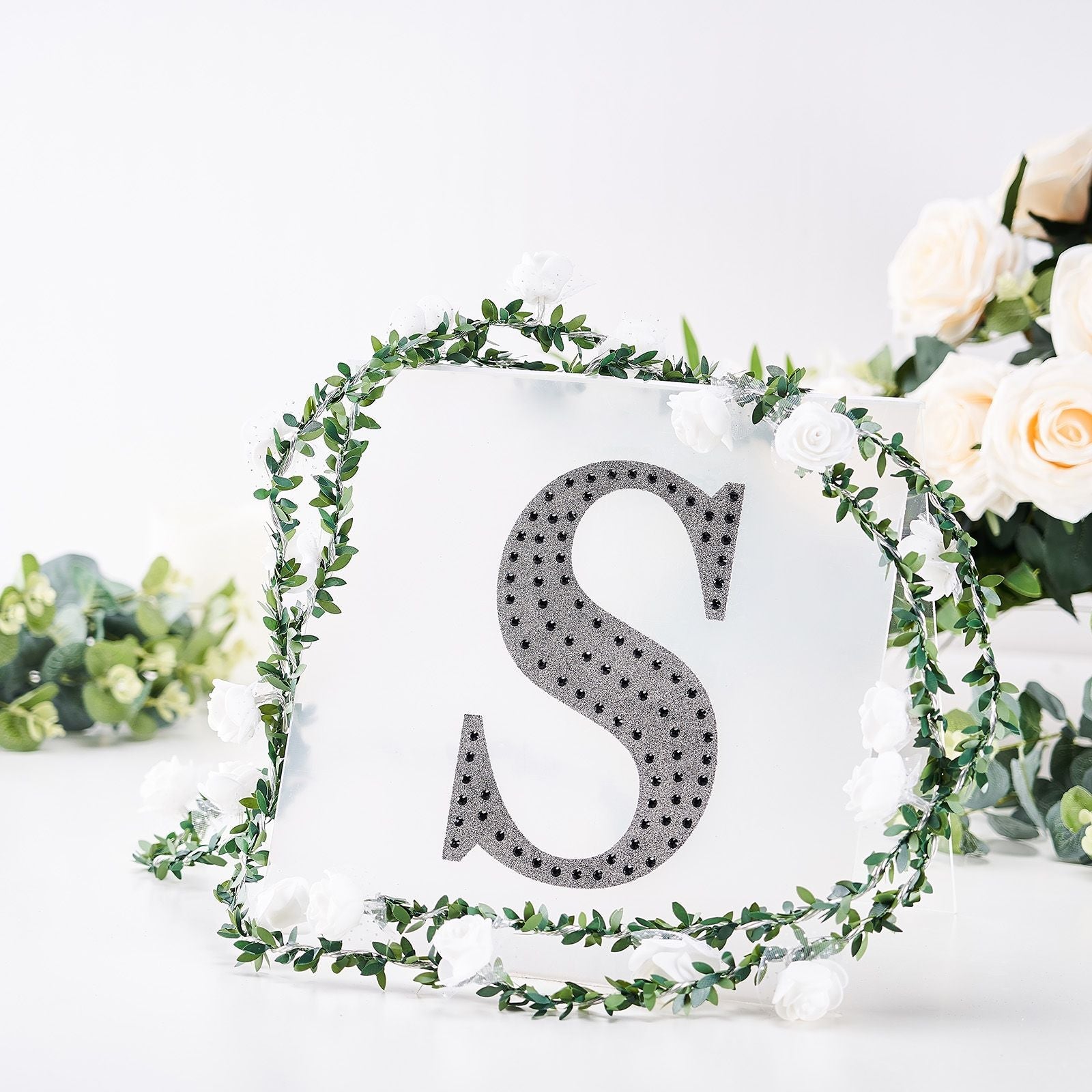 Black decorative rhinestone letter sticker "S" with floral accents.