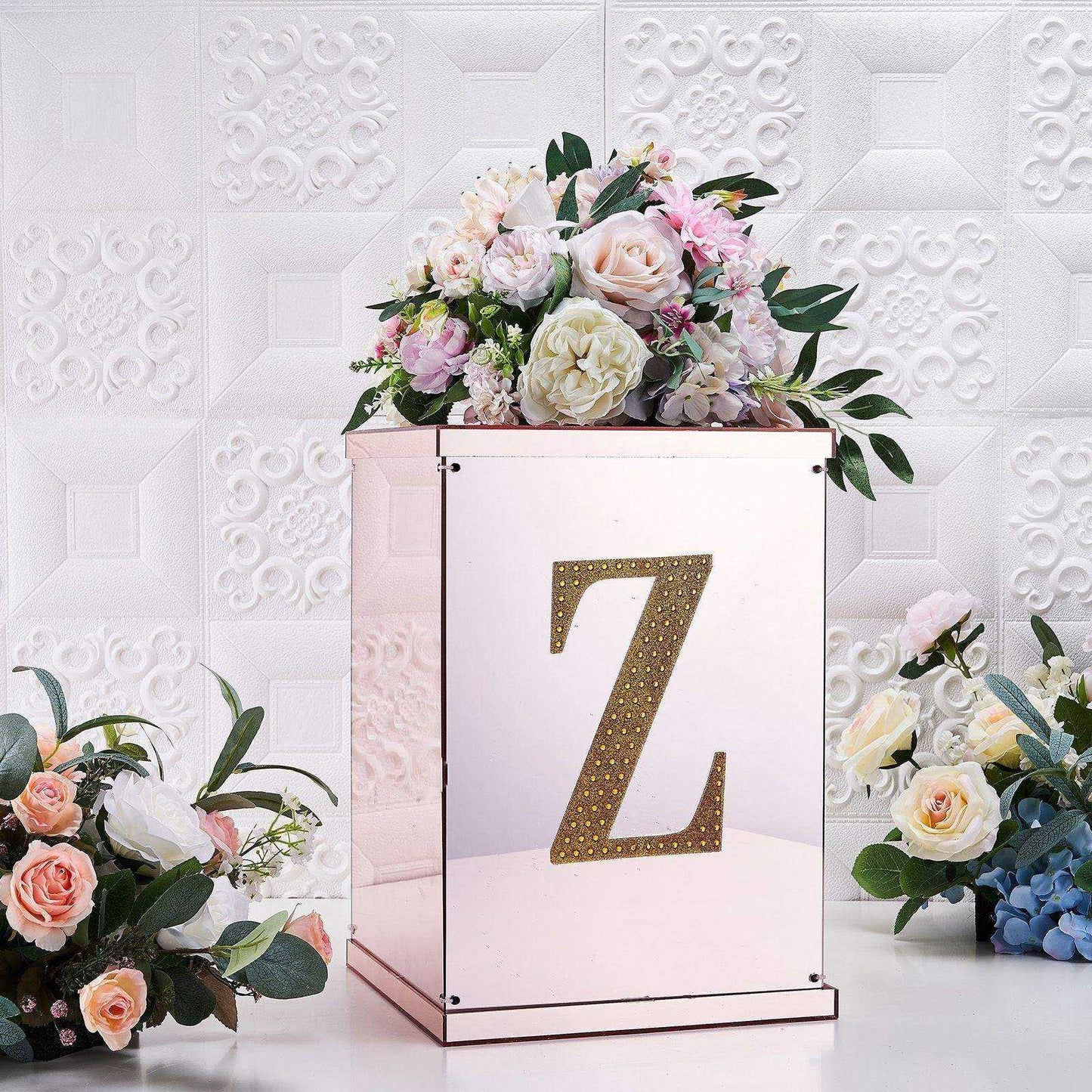 Gold decorative rhinestone letter "Z" on a floral arrangement display.