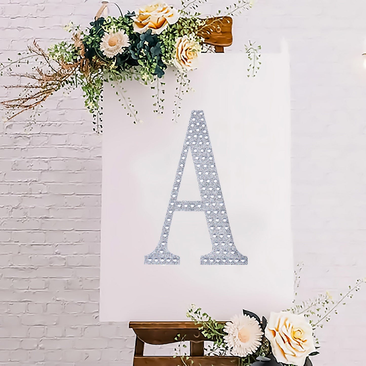 Silver decorative rhinestone letter "A" on a floral background.