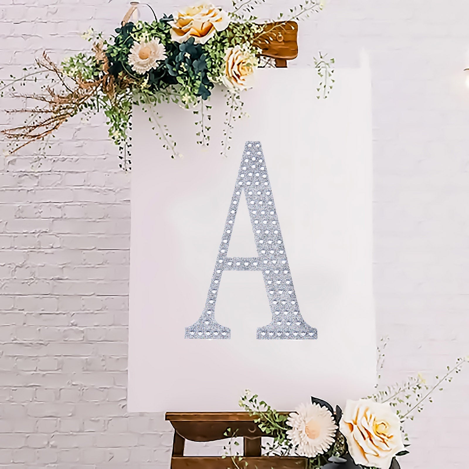 Silver decorative rhinestone letter "A" on a floral background.