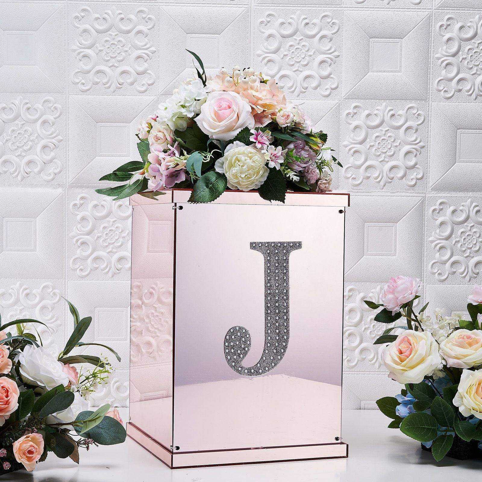 Silver decorative rhinestone letter "J" with flowers in a pink vase.