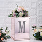Silver decorative rhinestone letter "M" with flowers in a pink vase.