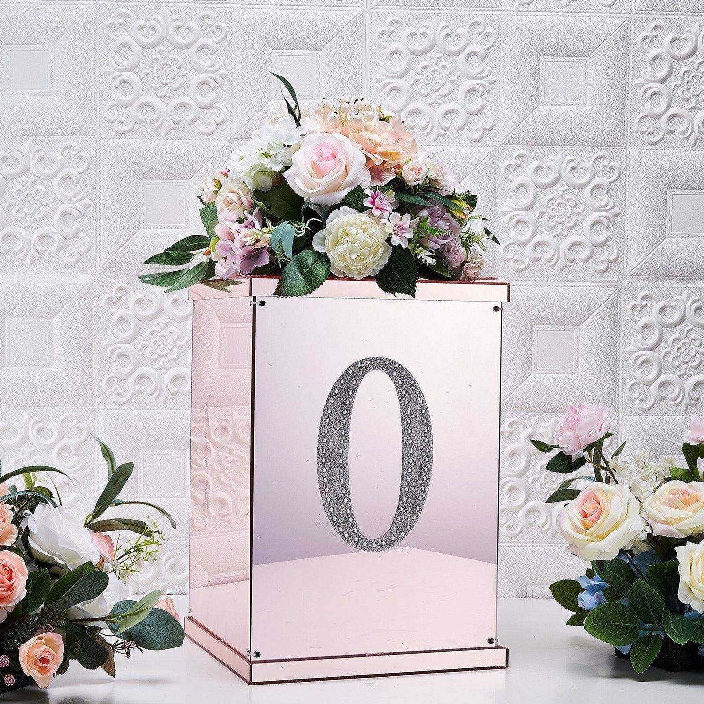 Silver decorative rhinestone letter "O" sticker on a floral arrangement.