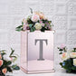 Silver decorative rhinestone letter "T" on a floral arrangement.