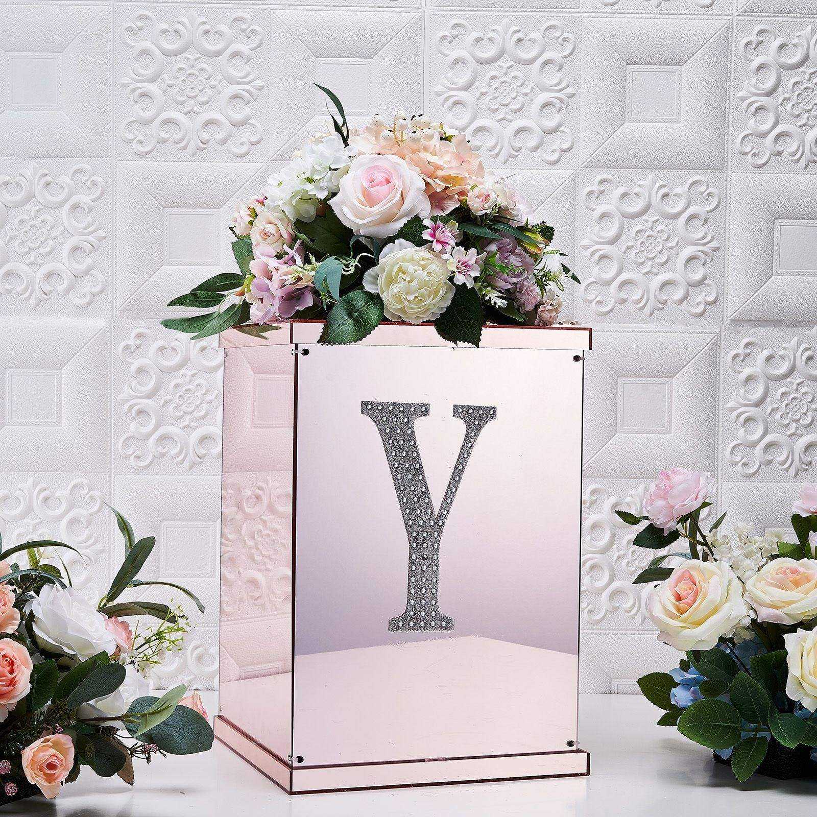 Silver decorative rhinestone letter "Y" on a floral arrangement.