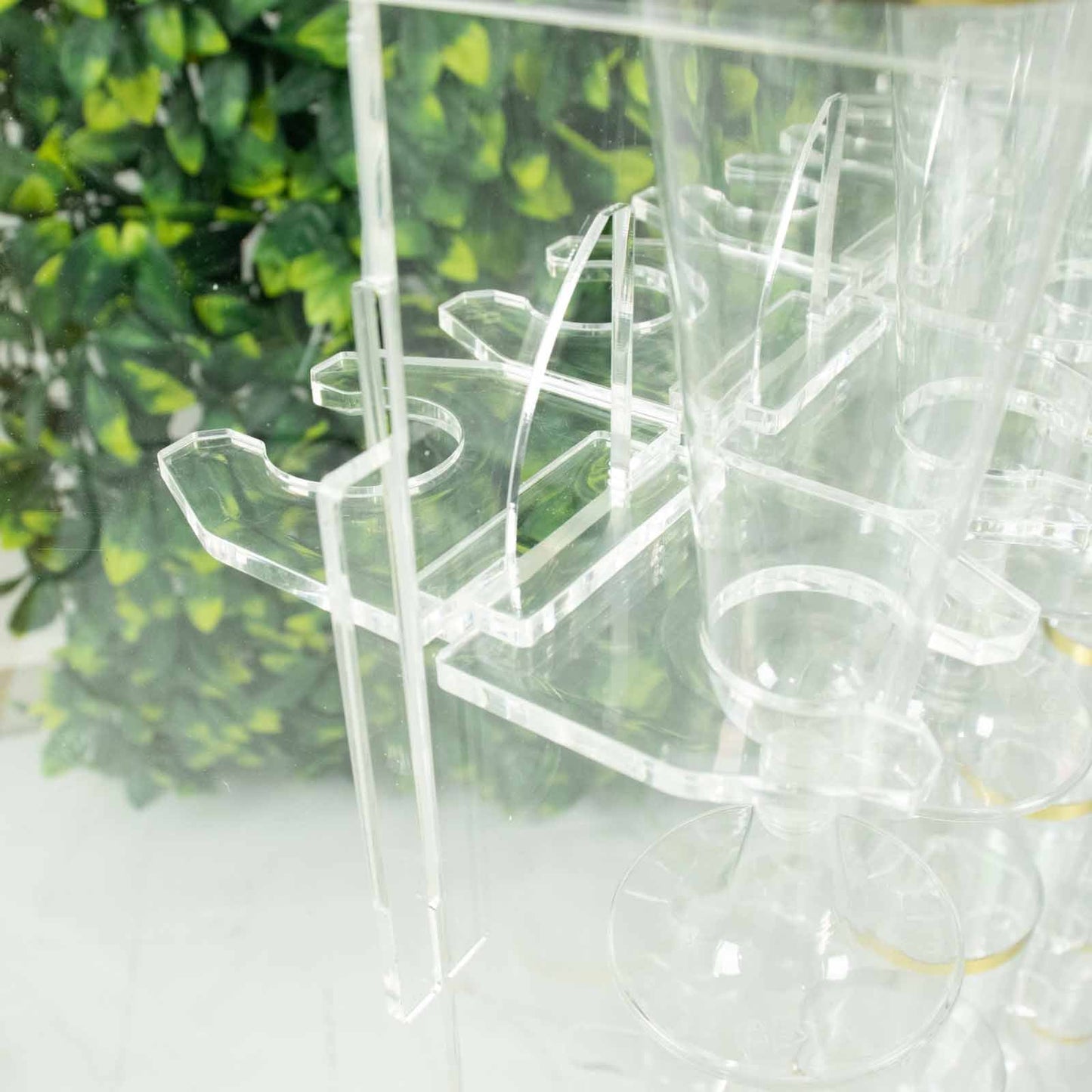 Clear acrylic glass holder hooks for double-sided display on a champagne rack stand.