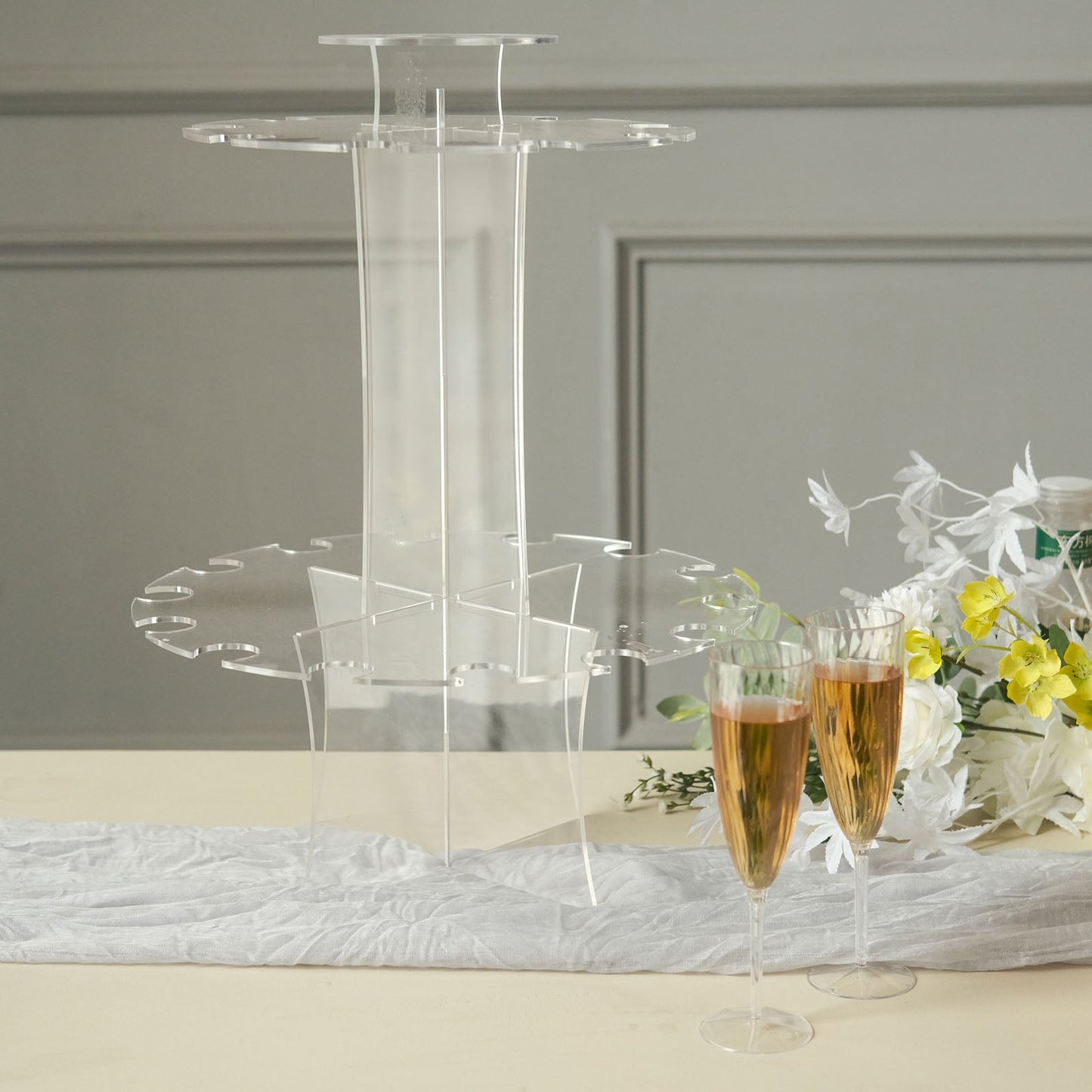 Clear acrylic champagne glasses display stand with flutes and flowers.
