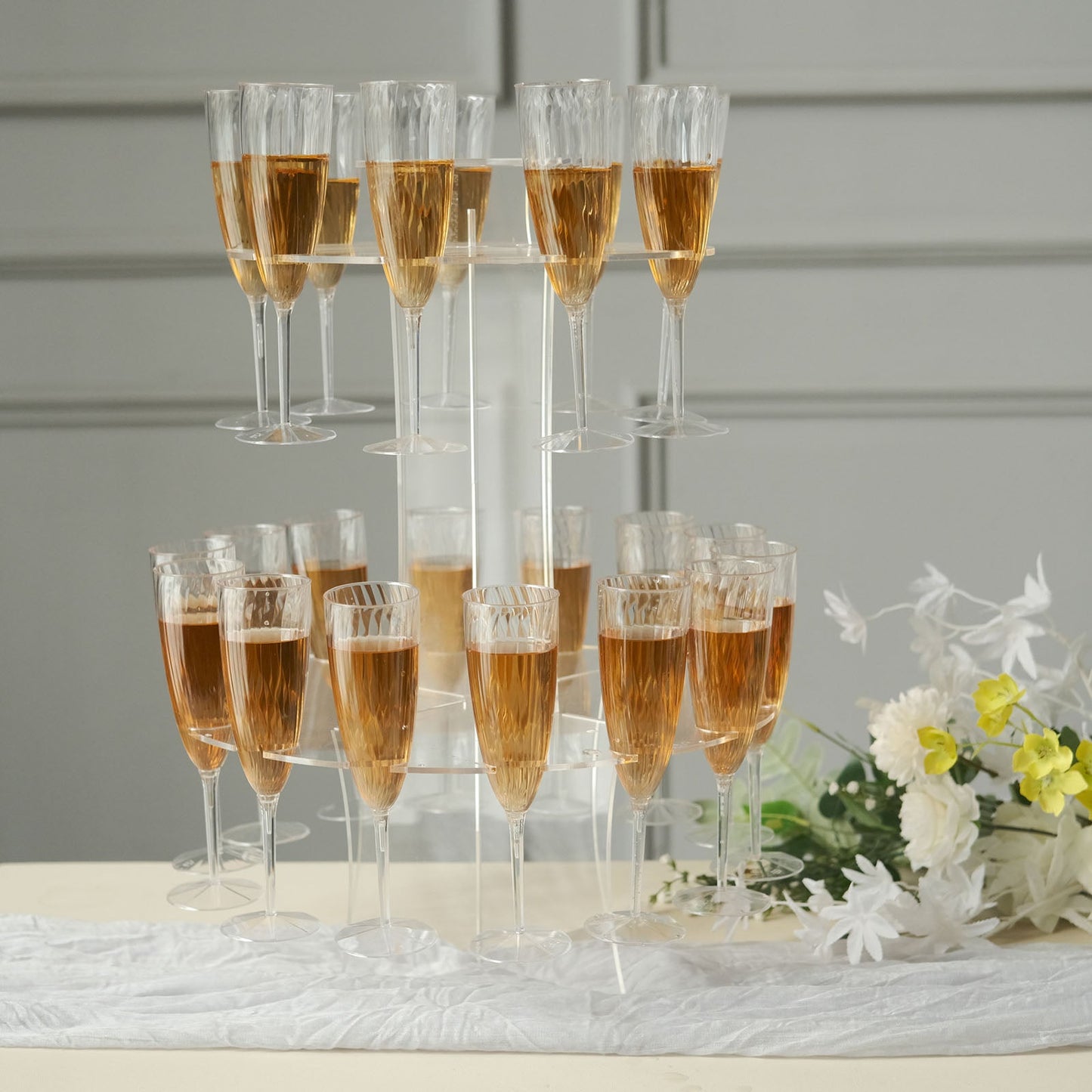 Clear acrylic champagne glasses display stand with flutes and wine rack tower.