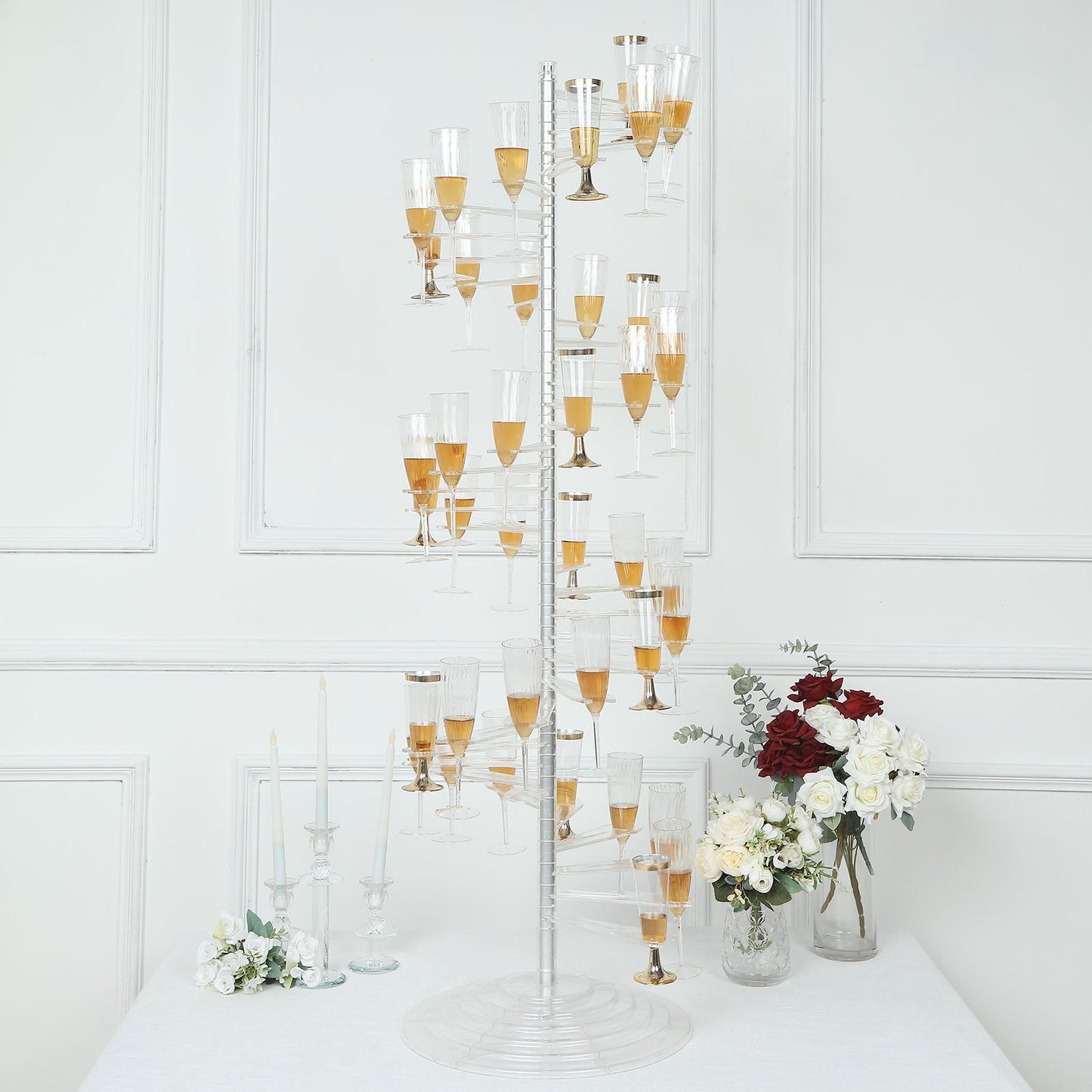 Clear acrylic spiral cocktail tree stand with champagne flutes and wine glass holders.