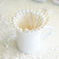 Natural pearl bamboo skewers in a white mug. Eco-friendly cocktail picks.