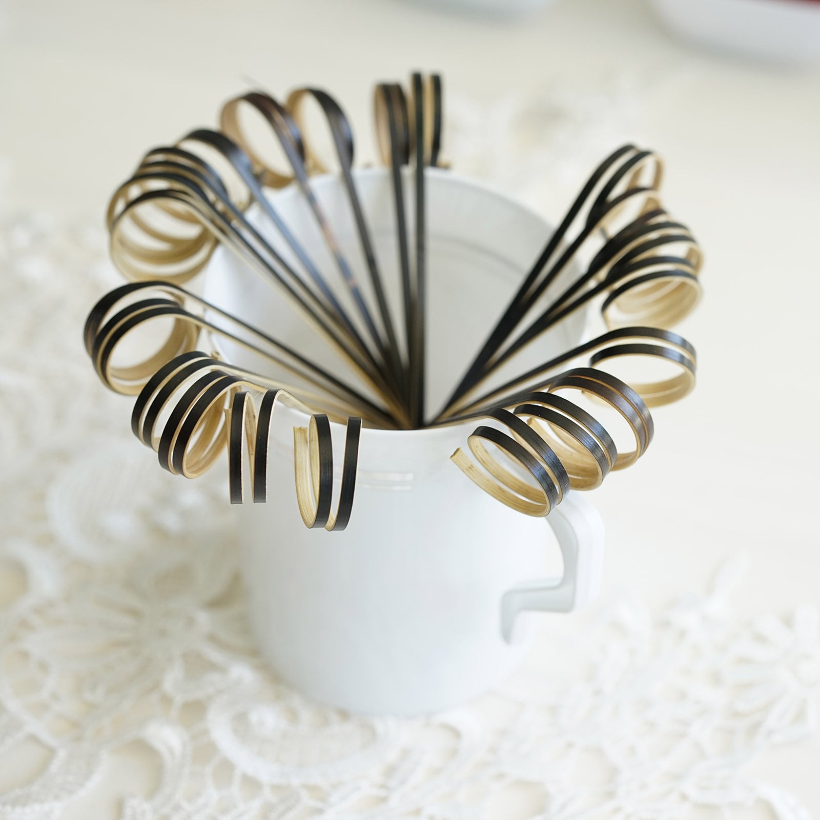 Black eco-friendly loop ring party picks in a white cup.