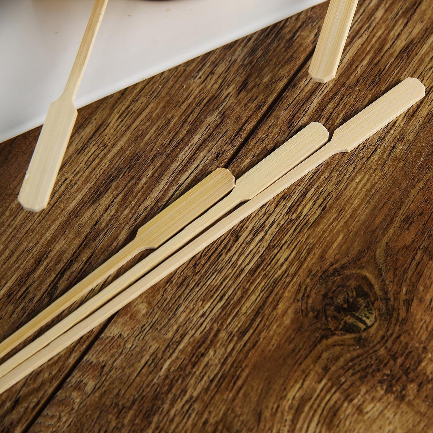 Eco-friendly bamboo party picks on a wooden surface.