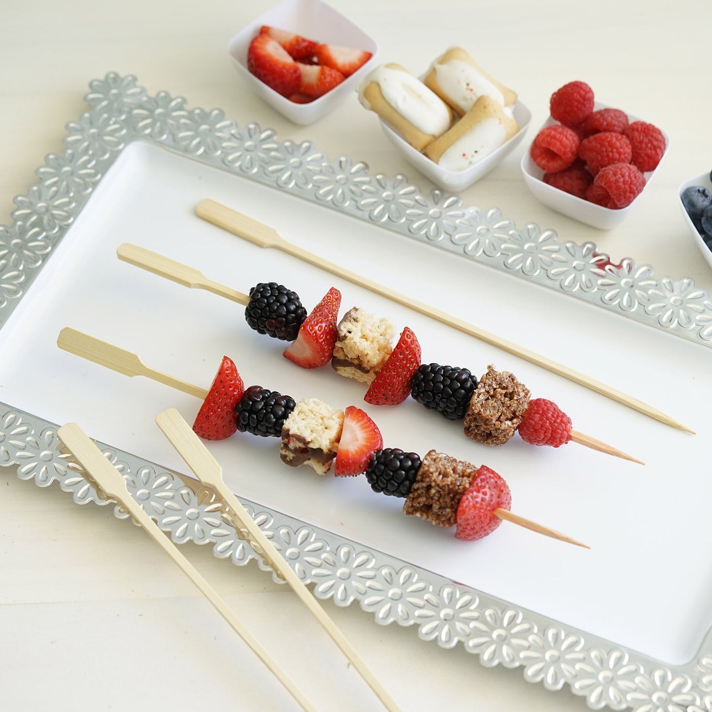 Eco-friendly bamboo paddle party picks with colorful fruit skewers.