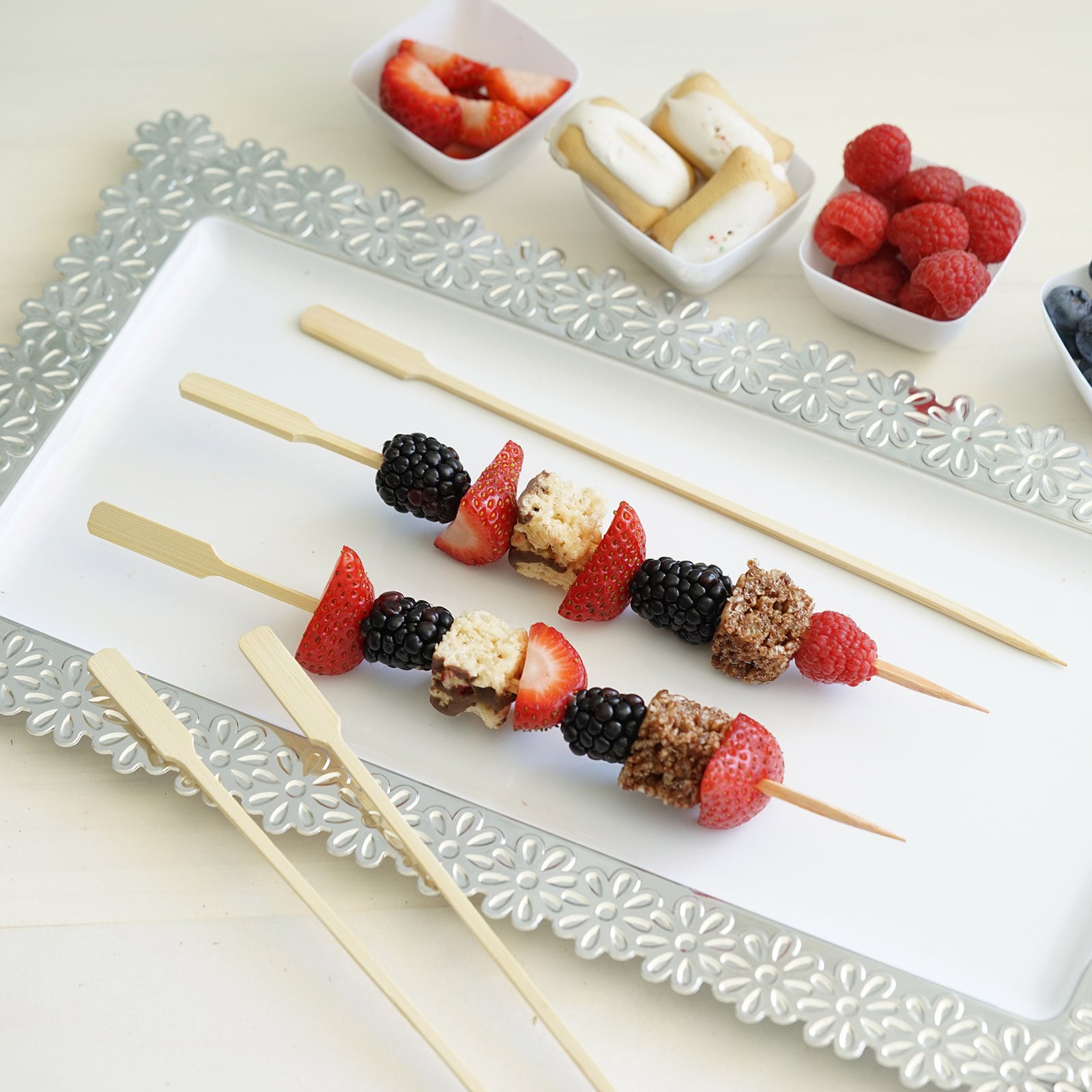 Eco-friendly bamboo paddle party picks with colorful fruit skewers.