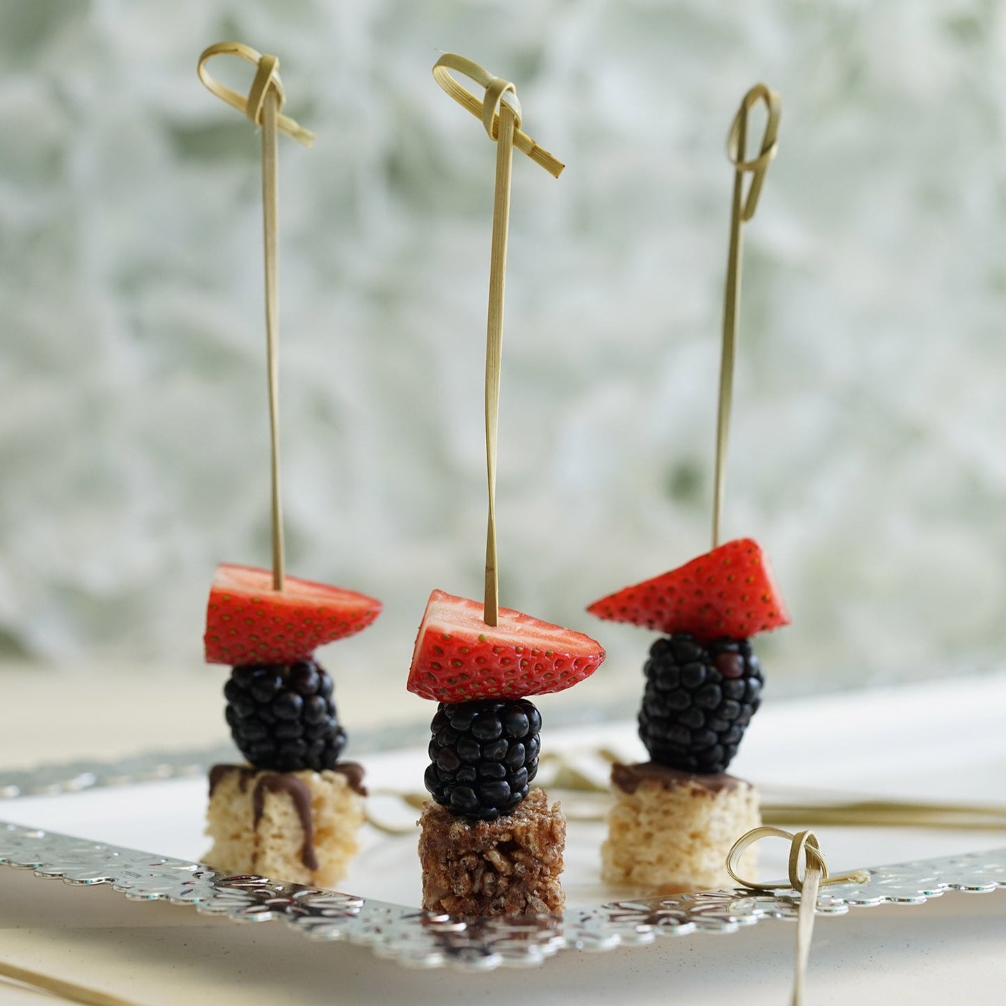 Eco-friendly twisted knot cocktail sticks with decorative tops on a platter.