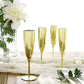 Metallic gold disposable champagne flutes on a table setting.