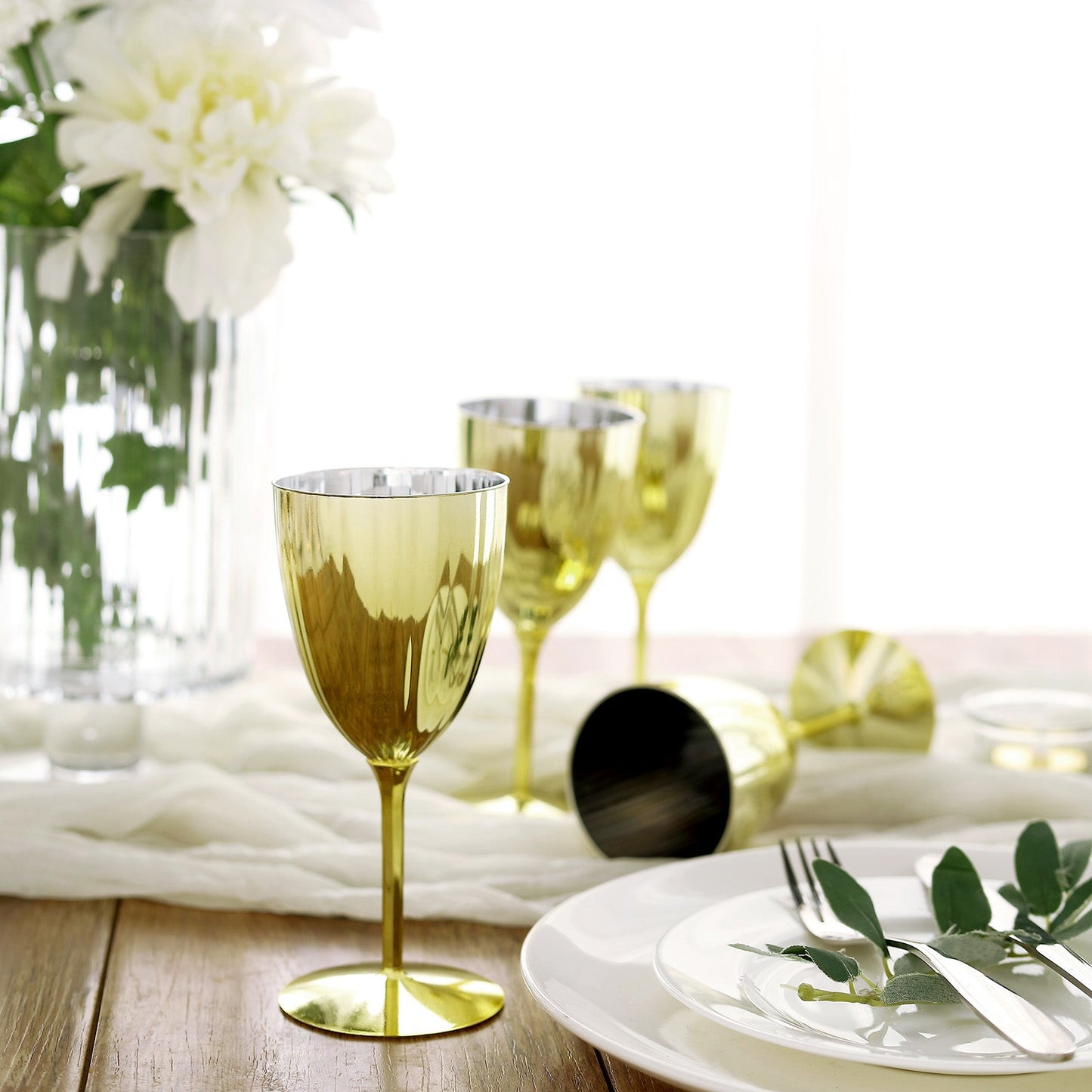 Gold disposable wine glasses in a stylish table setting.