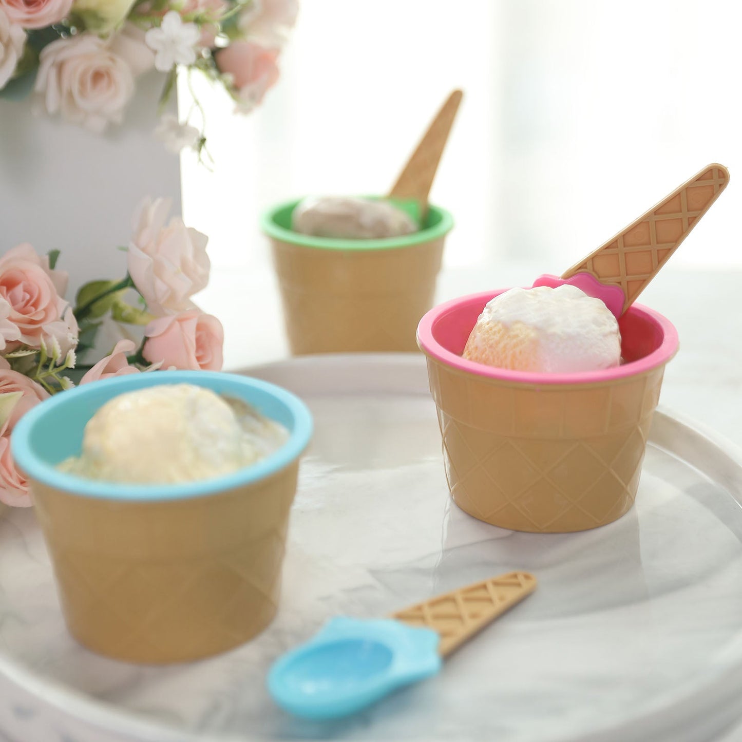 Colorful reusable ice cream cone bowls and spoons in blue, green, and pink.