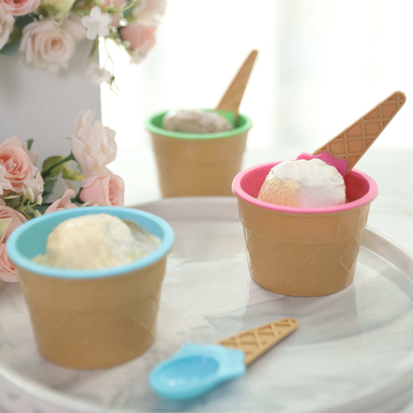 Colorful reusable ice cream cone bowls and spoons in blue, green, and pink.
