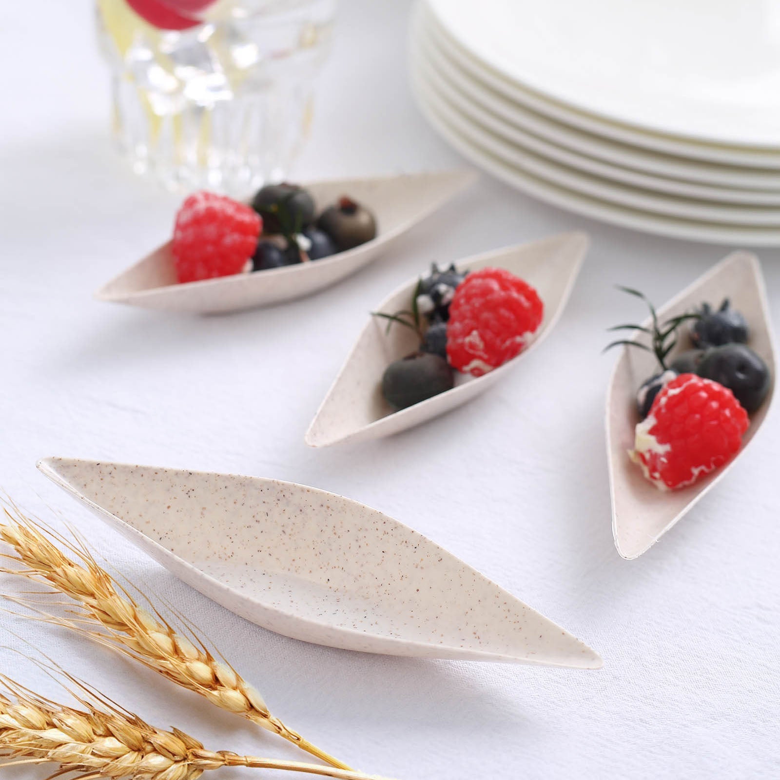 Beige mini boat-shaped dessert plates with berries.