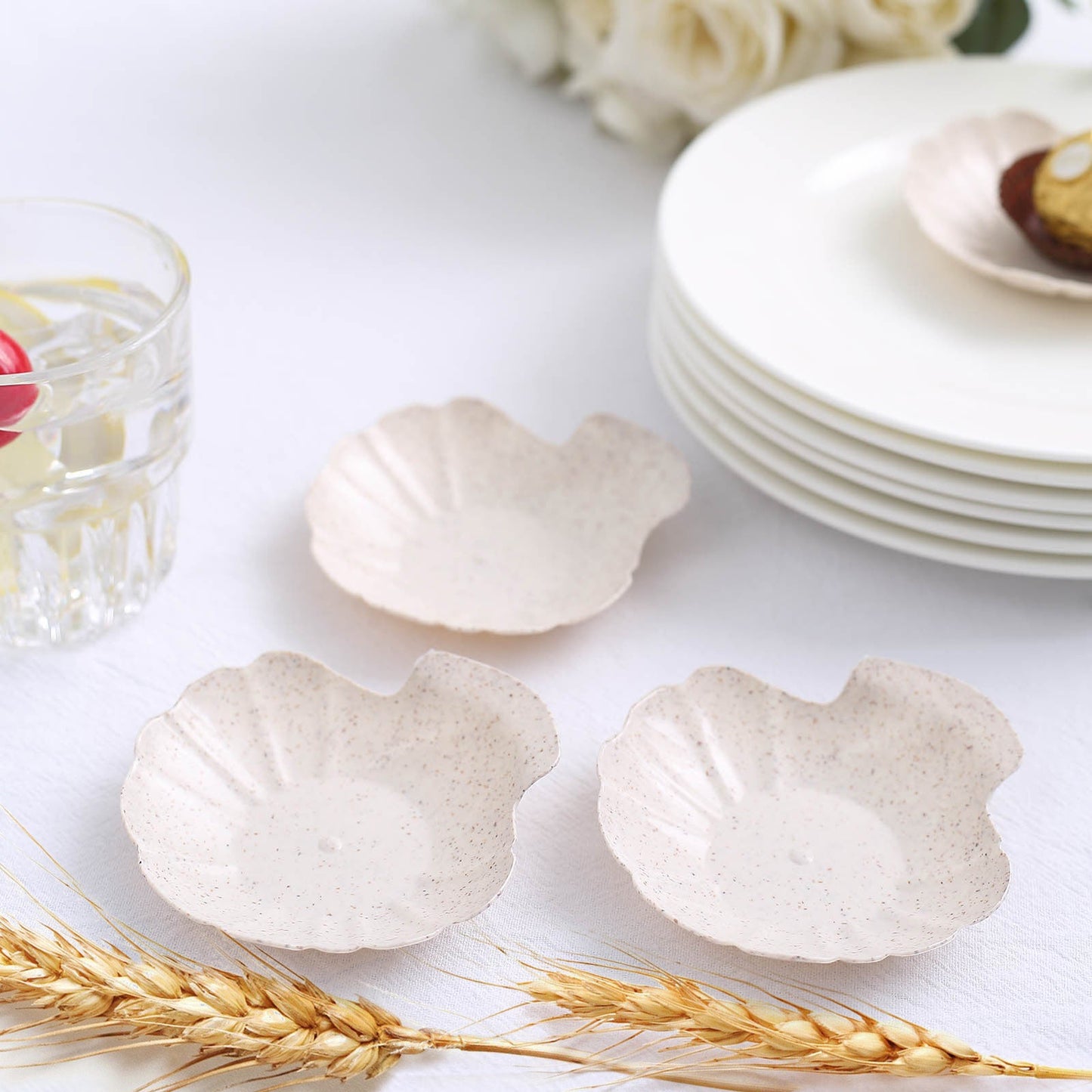 Biodegradable mini sea shell plates in light beige, perfect for appetizers.
