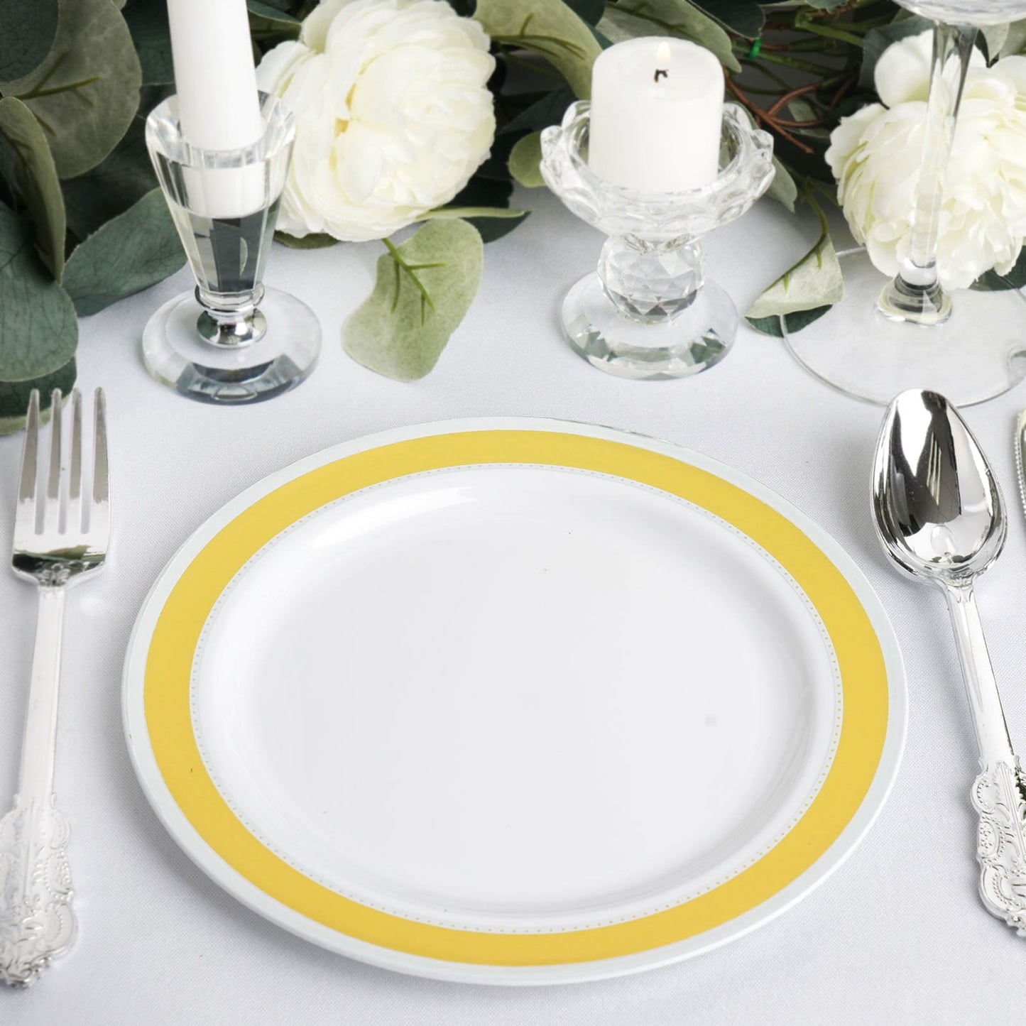 White 7" round plates with gold and silver rim, set on a table setting.