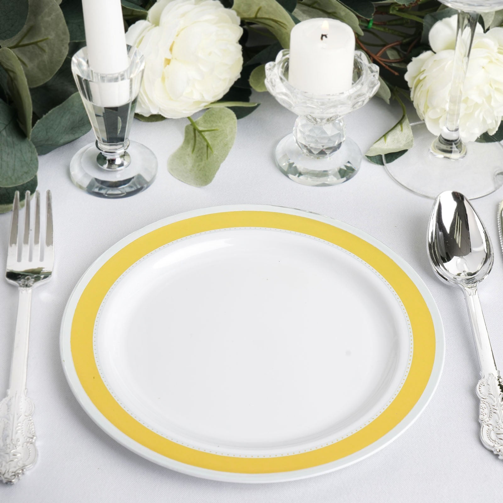White 7" round plates with gold and silver rim, set on a table setting.