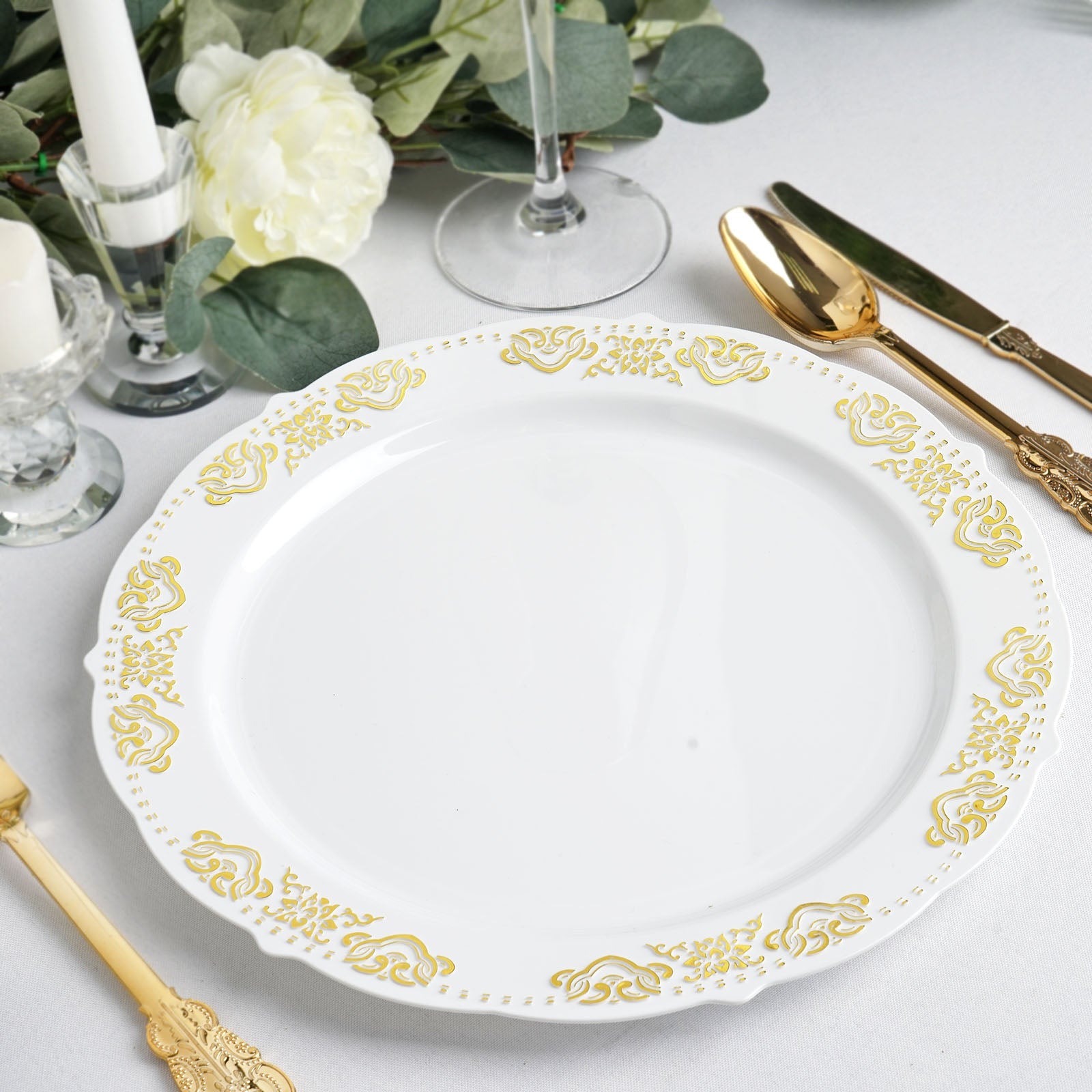 Gold embossed white plastic dinner plate with scalloped edges.