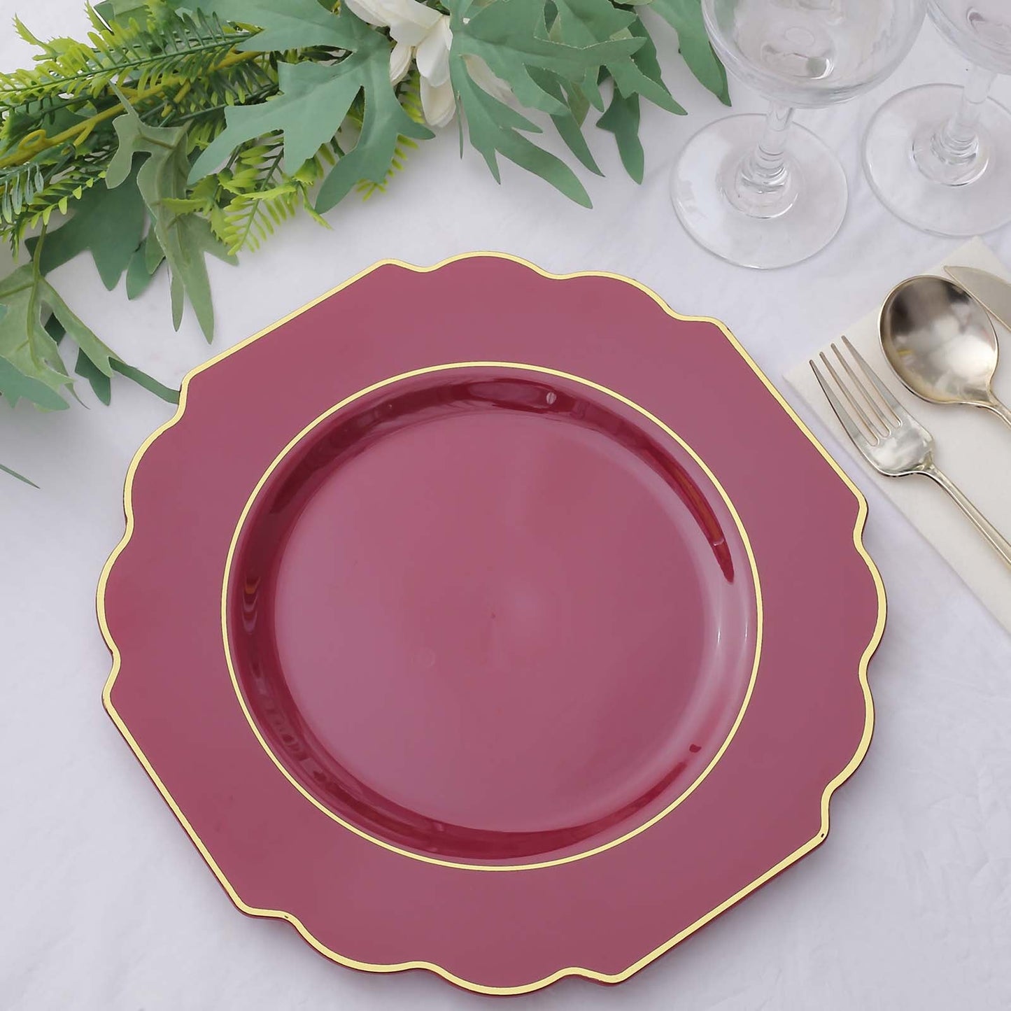 Burgundy hard plastic Baroque dinner plate with gold rim.